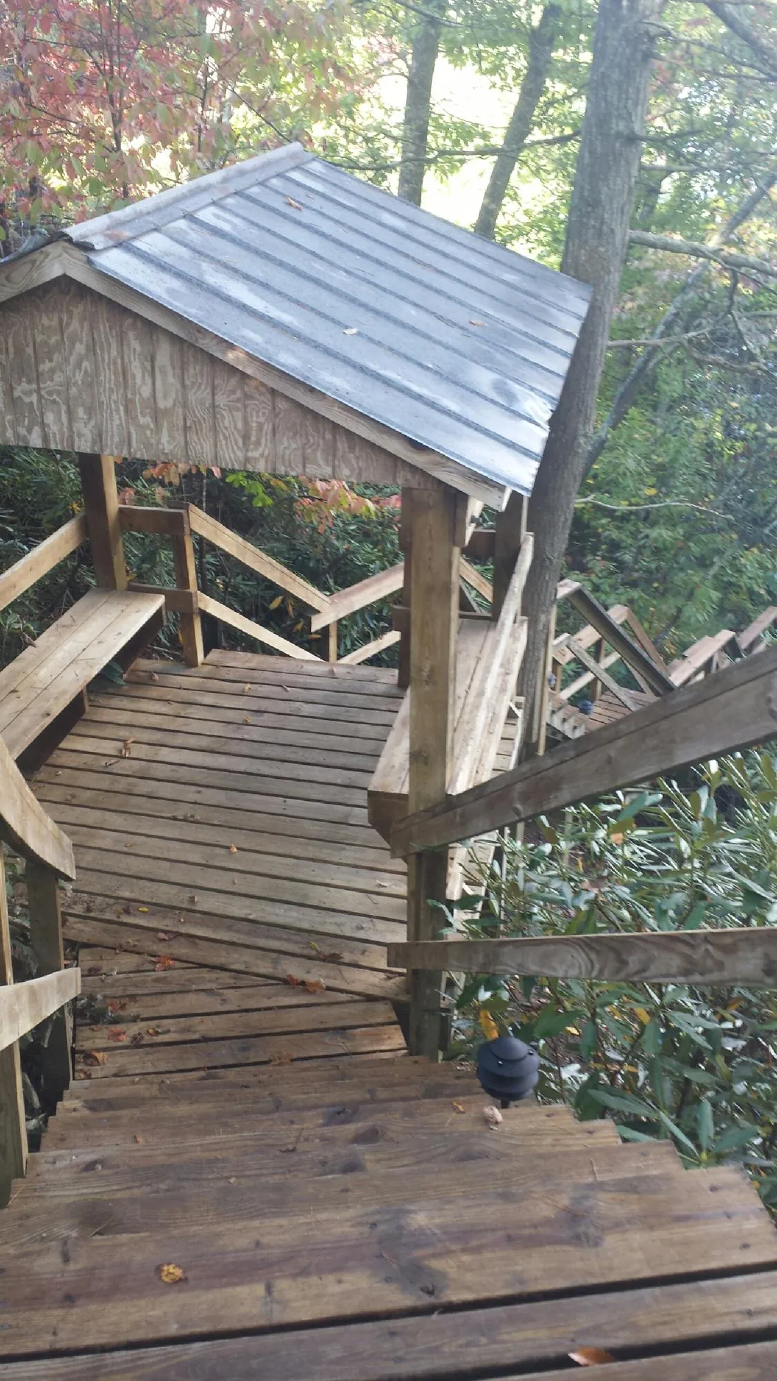 Metal roofed shelter over wooden steps on a wooded walkway — Skylight Repair & Installation work by our crew in Cape May Court House